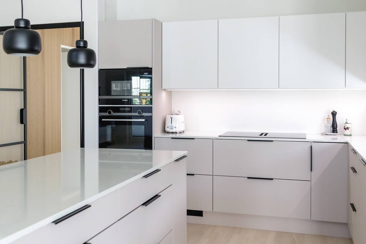 Las superficies de cocina de colores claros reflejan bien la luz de la encimera a su alrededor.